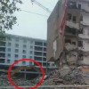 中国でマンションが倒れてきて建設機械が下敷きになる